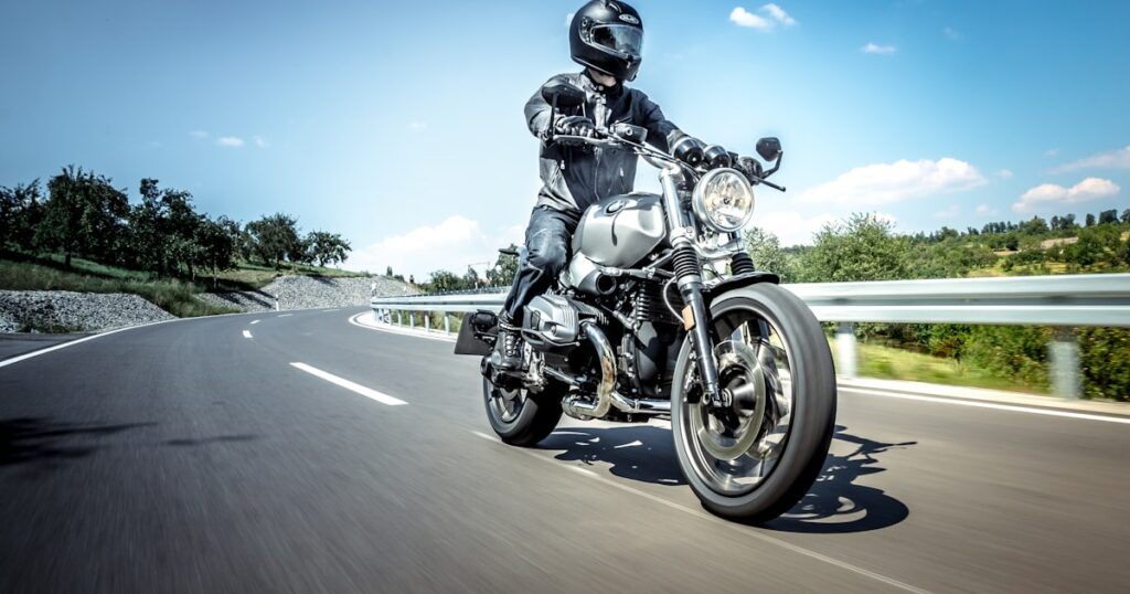 A motorcyclist in full protective gear riding on an open road, illustrating a motorbike accident claim